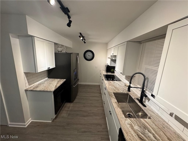 kitchen with light stone countertops, sink, and white cabinets