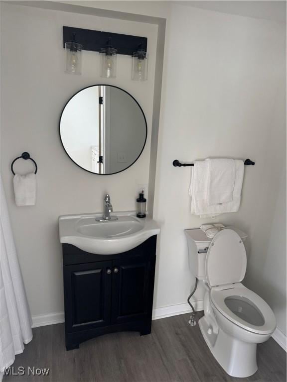 bathroom featuring vanity, wood-type flooring, and toilet