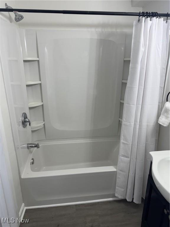 bathroom with shower / bathtub combination with curtain, vanity, and hardwood / wood-style flooring