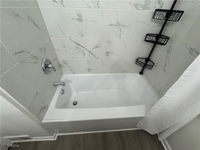 bathroom featuring tiled shower / bath and wood-type flooring