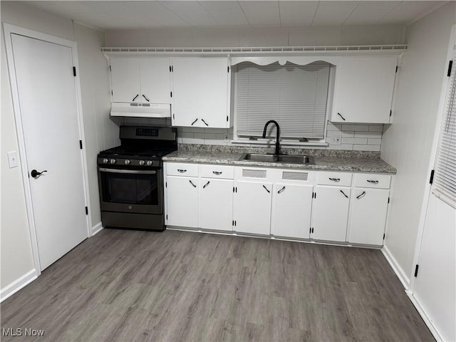 kitchen featuring white cabinetry, stainless steel gas range oven, wood-type flooring, and sink