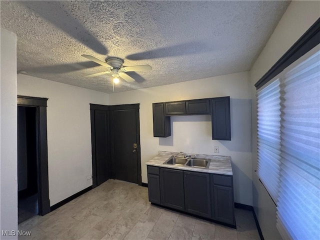 kitchen with ceiling fan, sink, and a textured ceiling