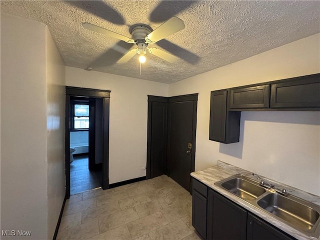 kitchen featuring ceiling fan, sink, and a textured ceiling