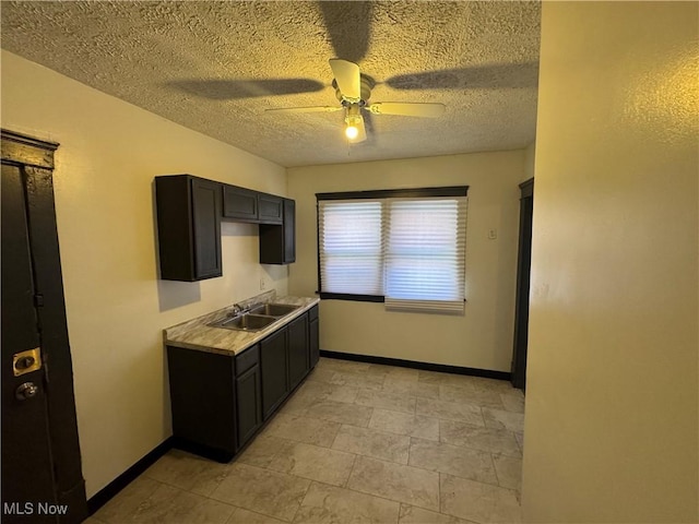 kitchen with sink, a textured ceiling, and ceiling fan