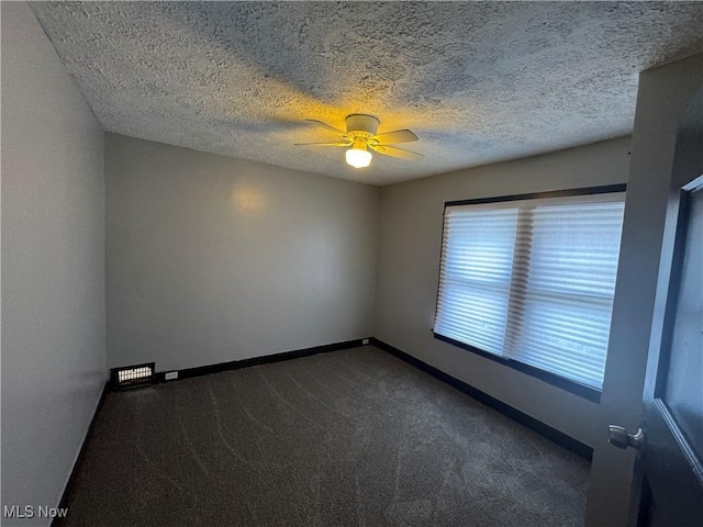 spare room featuring ceiling fan, a textured ceiling, carpet, and a wealth of natural light