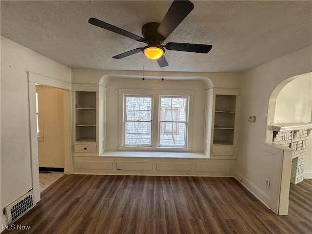 interior space with ceiling fan, dark wood-type flooring, and a textured ceiling