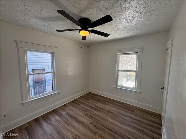 empty room with dark wood-type flooring, ceiling fan, and a textured ceiling