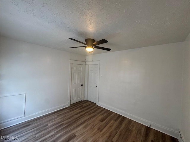 unfurnished room with ceiling fan, a textured ceiling, and dark hardwood / wood-style flooring