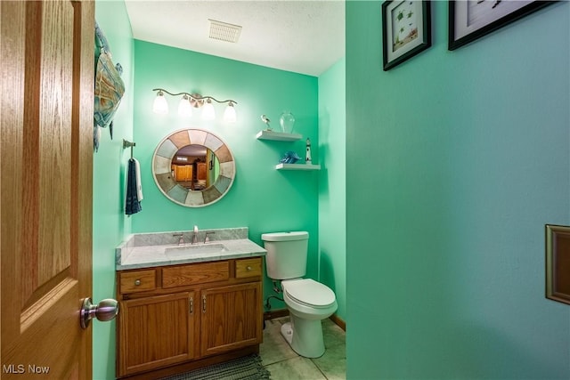 bathroom featuring vanity, tile patterned flooring, and toilet