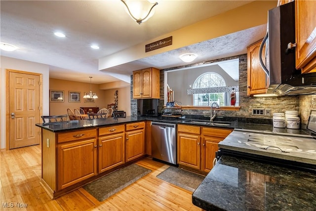 kitchen with sink, light wood-type flooring, kitchen peninsula, dishwasher, and pendant lighting