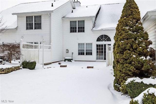 view of snow covered rear of property