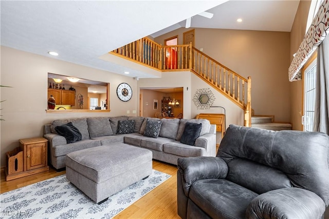 living room with high vaulted ceiling and light hardwood / wood-style floors