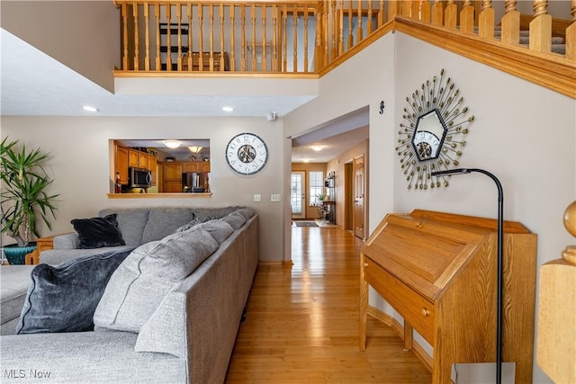 living room with light hardwood / wood-style floors and a high ceiling