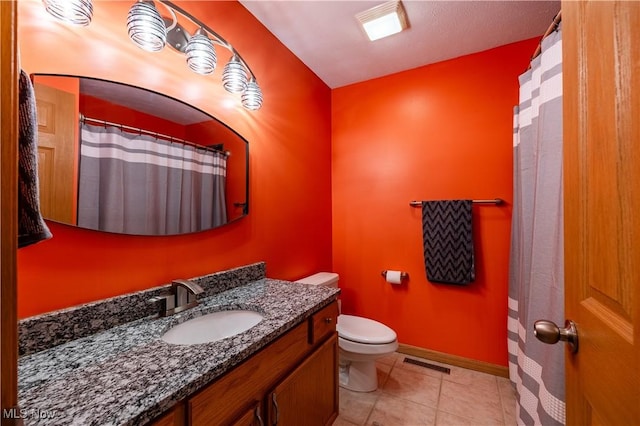 bathroom with vanity, toilet, and tile patterned flooring