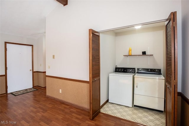 washroom with washing machine and clothes dryer and light hardwood / wood-style flooring