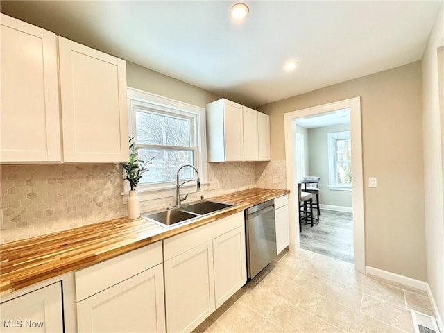 kitchen featuring dishwasher, decorative backsplash, white cabinets, sink, and wood counters