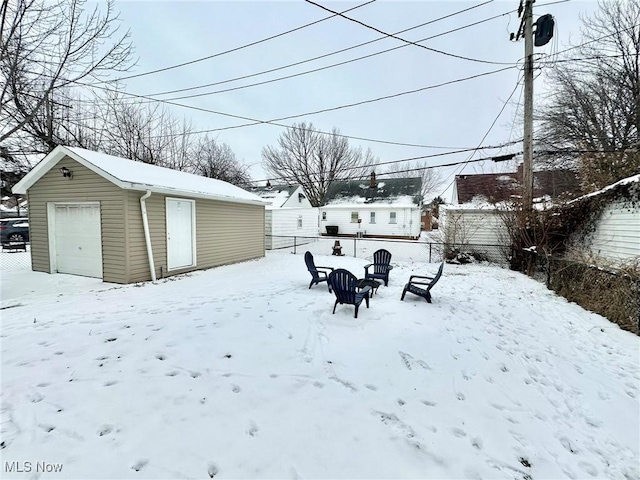 yard layered in snow with a garage and an outbuilding