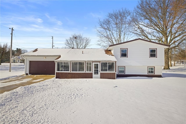 view of front facade with a garage and a sunroom