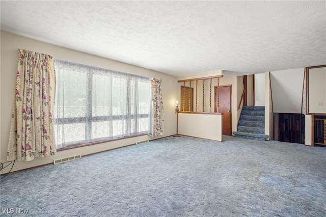 unfurnished living room with a textured ceiling and carpet flooring