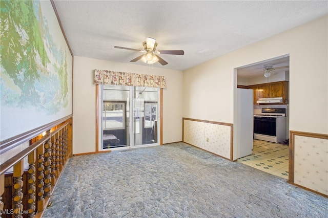 carpeted empty room with ceiling fan and a textured ceiling