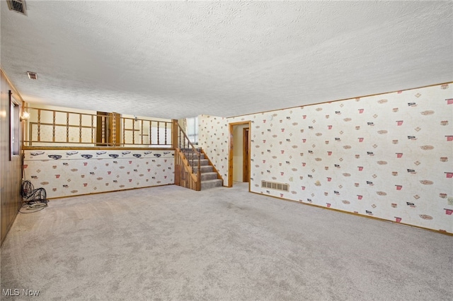 carpeted empty room with a textured ceiling