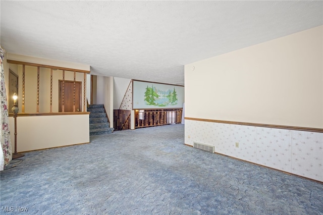 carpeted empty room featuring a textured ceiling