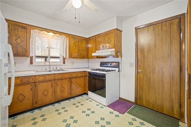 kitchen featuring sink, ceiling fan, white appliances, and decorative backsplash