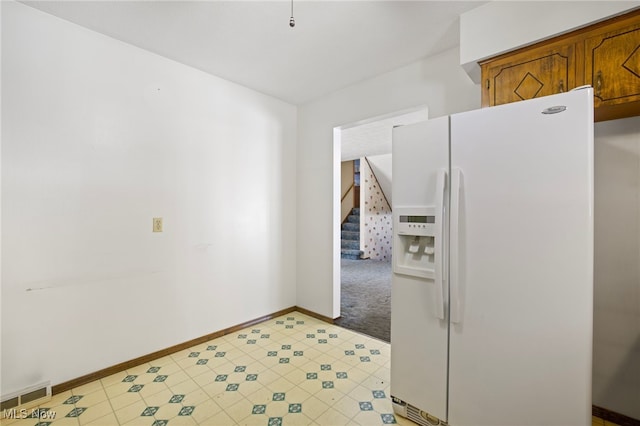 kitchen with white fridge with ice dispenser and light carpet