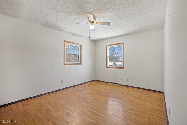 empty room featuring ceiling fan, a textured ceiling, and light wood-type flooring