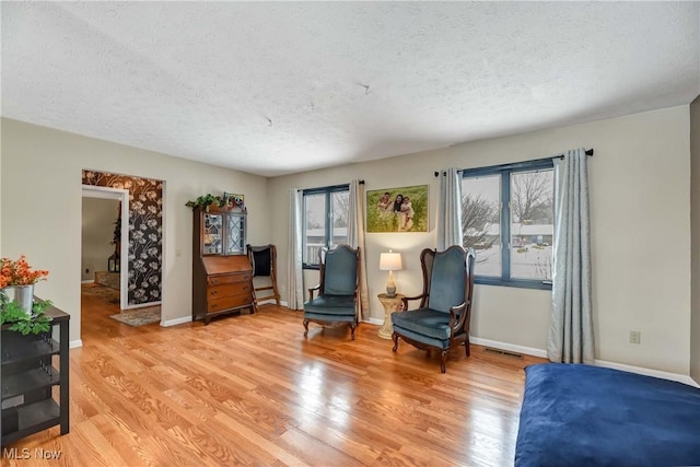 sitting room with light hardwood / wood-style floors and a textured ceiling