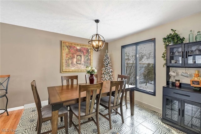 dining area featuring a notable chandelier and a textured ceiling