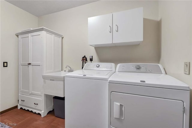 clothes washing area with cabinets, wood-type flooring, and separate washer and dryer