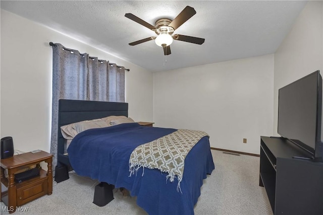 carpeted bedroom featuring a textured ceiling and ceiling fan