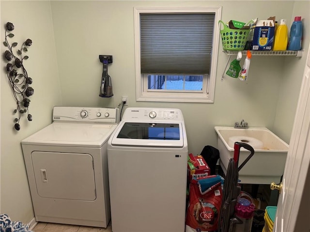 clothes washing area with sink, washing machine and dryer, and light tile patterned flooring