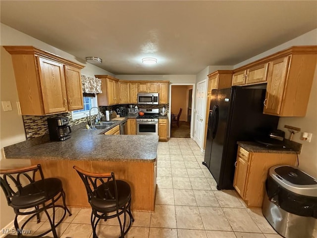 kitchen with tasteful backsplash, stainless steel appliances, a kitchen breakfast bar, and kitchen peninsula