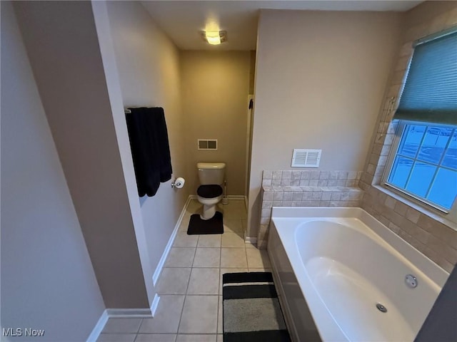 bathroom featuring tile patterned floors, toilet, and a tub