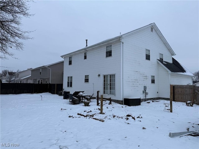 view of snow covered rear of property