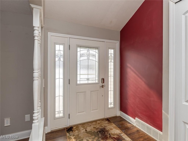 entryway with vaulted ceiling and dark hardwood / wood-style floors