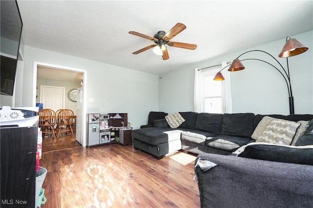 living room with dark wood-type flooring and ceiling fan