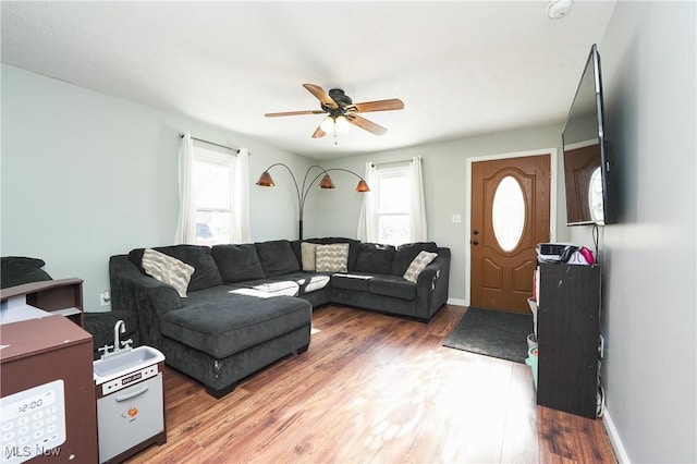 living room with ceiling fan, plenty of natural light, and dark hardwood / wood-style floors