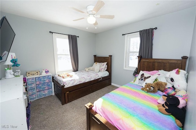 carpeted bedroom featuring multiple windows and ceiling fan