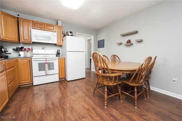 kitchen featuring dark wood-type flooring and white appliances