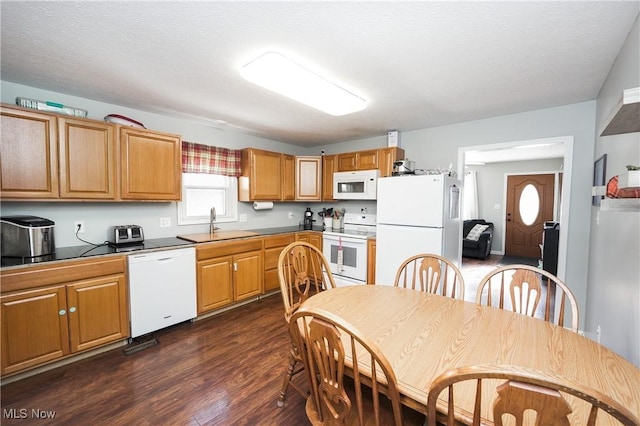 kitchen featuring sink, white appliances, dark hardwood / wood-style floors, and a textured ceiling