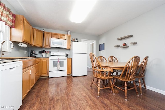 kitchen with dark wood-type flooring, white appliances, and sink