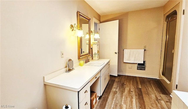 bathroom featuring walk in shower, vanity, and hardwood / wood-style floors