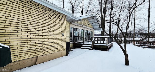 snow covered property with a wooden deck