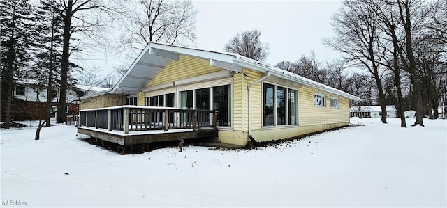 view of snow covered exterior featuring a wooden deck