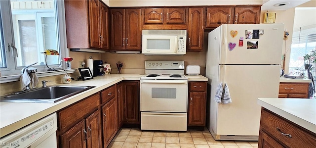 kitchen with sink, white appliances, and light tile patterned flooring