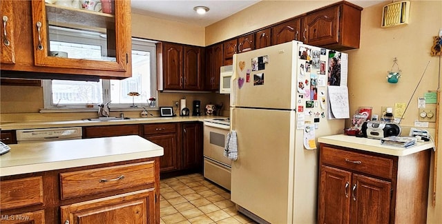 kitchen with sink, light tile patterned floors, and white appliances