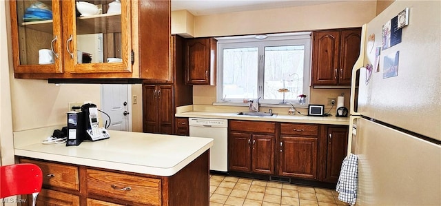 kitchen featuring white appliances, sink, and light tile patterned floors